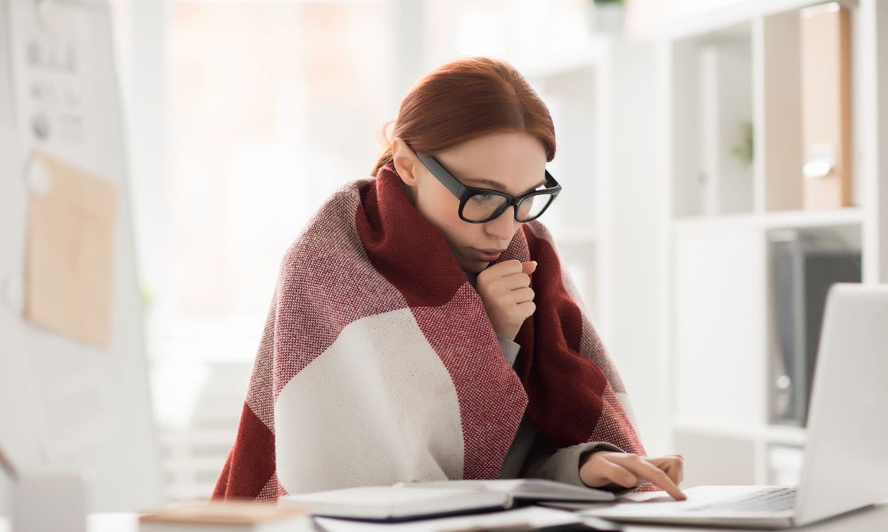 風邪を引くなど体調が悪いのにパソコンに向かう女性