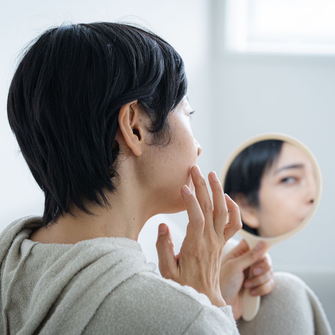 肌を見て悩んでいる女性